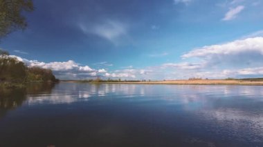 Nehir ya da Göl manzarası. Suyun içindeki bulutlu gökyüzünün yansımaları. Akşamları ya da sabah saatlerinde sakin suyun dalgalanması. Orman diğer tarafta. Doğu Avrupa 'nın Doğası
