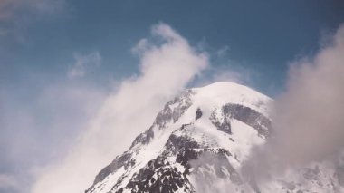 Kazbegi, Georgia. Kazbek Dağı 'nın zirvesi karla kaplı. Kazbek bir Stratovolcano ve Gürcistan Kazbegi ve Rusya sınırında yer alan Kafkasya 'nın en büyük dağlarından biridir..