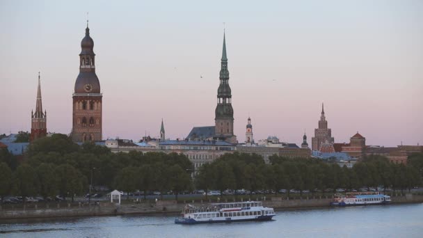 Riga, Lettonia. Nave da crociera galleggiante nel fiume Daugava. Vista panoramica del centro storico antico - Vecchie torri della Chiesa sullo sfondo. Destinazione di viaggio. UNESCO — Video Stock