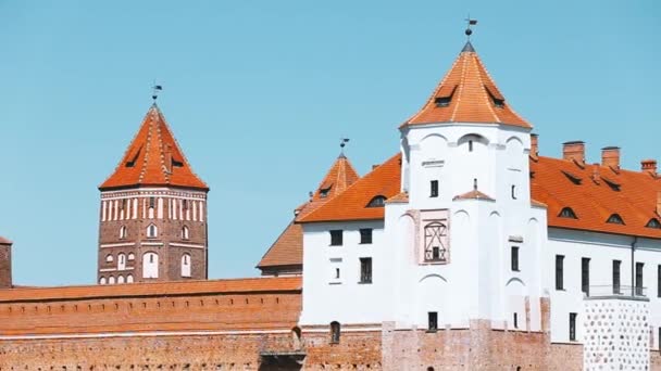 Mir, Wit-Rusland. Scenic uitzicht op Mir Castle Complex van kant van het meer. Architectonisch ensemble van het eudalisme, eeuwenoud cultureel monument, UNESCO Werelderfgoed. Beroemde bezienswaardigheid in de zomer Zonnige dag onder — Stockvideo