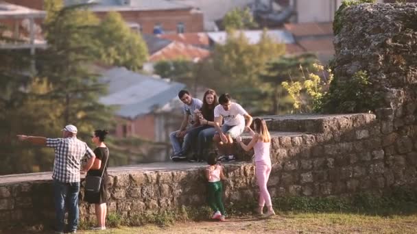 Kutaisi, Georgia. Persone che riposano passeggiando vicino alle vecchie mura della Cattedrale Bagrati in soleggiata sera d'estate. UNESCOs Patrimonio Mondiale dell'Umanità — Video Stock