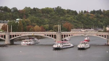 Prag, Çek Cumhuriyeti. Manes Köprüsü ve Vltava Nehri 'nin Sonbahar Günü manzarası. Vltava Nehri 'nde köprü altında yüzen tur tekneleri ve gezi gemileri