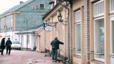 Kuressaare, Saaremaa Adası, Estonya. Bulutlu Kış Günü 'nde Kauba Caddesi' nde Yürüyen İnsanlar. Dar Sokaklardaki Eski Geleneksel Evler