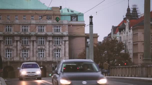 Praga, Republika Czeska. Wieczorny ruch na Manes Bridge. Ludzie przejeżdżający przez ulicę. — Wideo stockowe