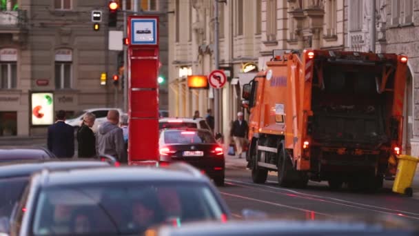 Popelářský vůz pracující na večerní ulici. Prachový vozík, popelářský vůz, popelářský vůz, popelářský vůz, popelářský vůz speciálně navržený pro sběr komunálního odpadu. — Stock video