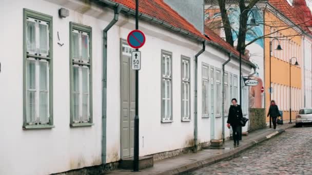 Курессааре, Сааремаа, Эстония. Люди ходят по улице в облачный зимний день. Старые традиционные дома на узких улицах — стоковое видео