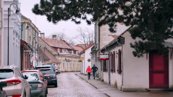 Kuressaare, ostrov Saaremaa, Estonsko. Lidé kráčející po Kaubské ulici v zamračeném zimním dni. Staré tradiční domy na úzkých ulicích — Stock video