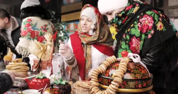 Gomel, Belarus. Femme s'habillant en pâtisserie nationale de commerce de vêtements folkloriques, crêpes pendant la célébration slave orientale fête nationale traditionnelle Maslenitsa. Vacances d'hiver de printemps — Video