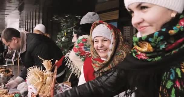 Gomel, Belarus. Femme s'habillant en pâtisserie nationale de commerce de vêtements folkloriques, crêpes pendant la célébration slave orientale fête nationale traditionnelle Maslenitsa. Vacances d'hiver de printemps — Video