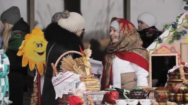 Gomel, Belarús. Mujer vestirse con ropa popular nacional comercio pastelería, tortitas durante la celebración eslava oriental nacional tradicional fiesta Maslenitsa. Vacaciones de invierno primavera — Vídeos de Stock