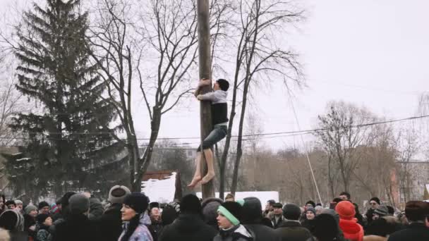 Gomel, Belarus. Genç Adam Baharın Geleceği Slav Kutlama Şrovedi 'ne adanmış geleneksel tatil gününde tahta bir direğe tırmanır. Ulusal Geleneksel Tatil Maslenitsa — Stok video