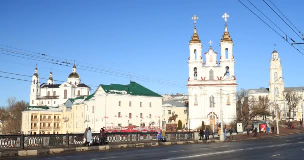 Vitebsk, Belarus. Circulation à Lenina Street et points de repère sur fond église de la résurrection du Christ sur la place du marché et l'hôtel de ville dans la journée ensoleillée d'hiver — Video