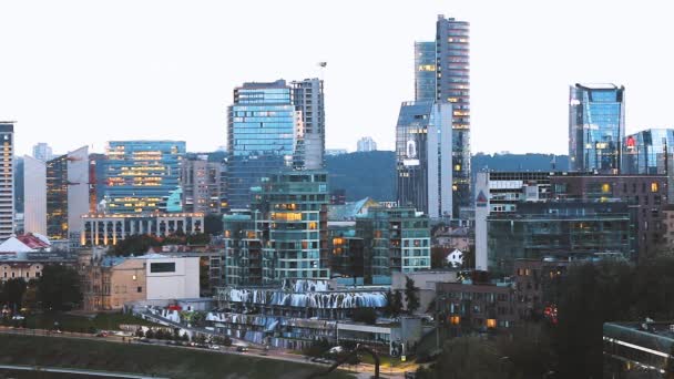 Vilnius, Litouwen. Stadsgezicht in de avondzomer. Mooi uitzicht op moderne kantoorgebouwen wolkenkrabbers in het zakendistrict New City Centre Shnipishkes — Stockvideo