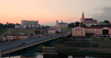 Grodno, Belarus. Neman Nehri 'nin karşısındaki köprü, bölgesel tiyatro tiyatrosu, St. Francis Xavier Katedrali ve Bernardine Manastırı Sunset veya Sunrise Time