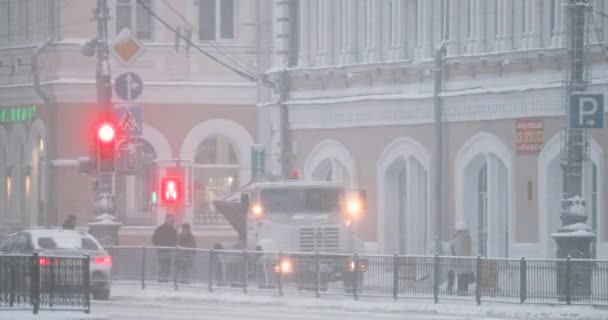 Homel, Białoruś. Specjalna maszyna posypuje solą i odczynnikami chemicznymi na ulicy Sovetskaya w zimowy śnieżny dzień — Wideo stockowe