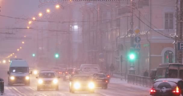 Gomel, Belarús. Tráfico de la ciudad en la calle Sovetskaya en invierno nevado tormenta de nieve por la noche — Vídeos de Stock