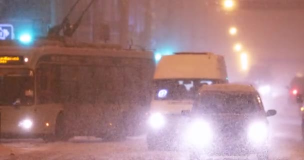 Stadsverkeer in de winter Sneeuwstorm 's avonds of' s nachts — Stockvideo