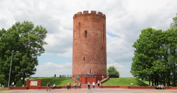 Kamyenyets, regio Brest, Belarus. Mensen wandelen in de buurt van de toren van Kamyenyets in de zomer dag — Stockvideo