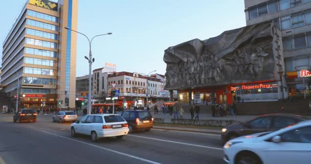 Minsk, Belarús Tráfico en la calle Pobediteley Cerca de Bajorrelieve de la era soviética en el antiguo edificio de la fachada en la calle Nemiga — Vídeos de Stock