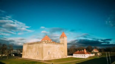 Kuressaare, Saaremaa, Estonya. Günbatımındaki Zaman Hızlandırması Episcopal Şatosu. Geleneksel Ortaçağ Mimarisi, Ünlü Cazibe Tarihi. Bulutlar Güneşli Gökyüzünde Hızlı Hareket Ediyor.