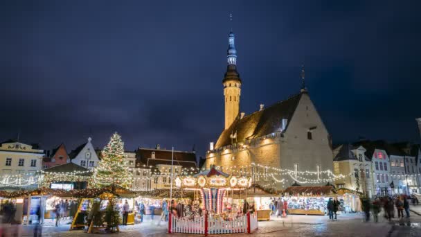 エストニアのタリン。町役場広場で伝統的なクリスマスマーケットやカルーセルのタイムラプス。クリスマスツリーと商社。有名なランドマークとユネスコ世界遺産 — ストック動画