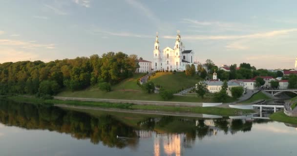 ベラルーシのヴィテブスク。アッパータウンの仮定大聖堂教会夏の夜の日没時にUspenskyマウントヒルとディヴィナ川で。ズームアウト、ズームアウト — ストック動画