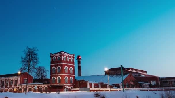 Dobrush, Gomel régió, Fehéroroszország. Időkiesés Időkiesés Estétől a régi papírgyár tornyának éjszakájáig a téli szezonban. Éjszakai csillagok égbolt Történelmi helyi nevezetesség felett — Stock videók