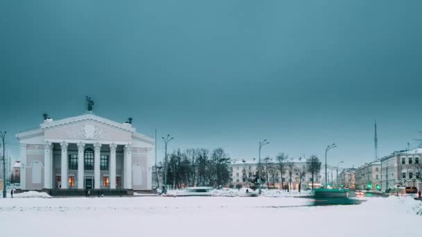 白俄罗斯，戈梅利时光流逝，时光流逝。在冬季列宁广场上的戈梅利地区剧院建筑附近的交通和灯光小径。日以继夜的变化 — 图库视频影像