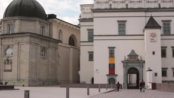 Βίλνιους, Λιθουανία. Άνθρωποι περπατούν στην πλατεία του καθεδρικού ναού κοντά στη Βασιλική του Αγίου Stanislaus και του Αγίου Vladislav με το καμπαναριό την Άνοιξη της Ευρώπης — Αρχείο Βίντεο