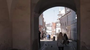 Vilnius, Litvanya. Güneşli bahar gününde Şafak Kapısı 'nda dikilen insanlar. Ünlü Dini, Tarihi ve Kültürel Anıt, Merhametli Meryem 'imizin mucizevi görüntüsüyle şapel