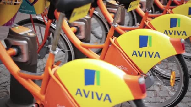 Vilnius, Lituanie. rangée de vélos colorés AVIVA à louer au stationnement municipal de vélo dans la rue . — Video