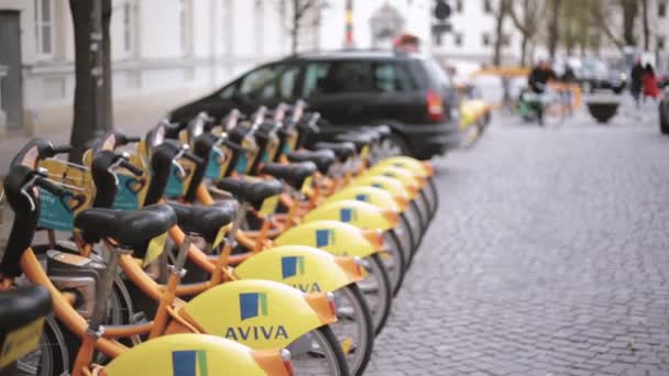Vilnius, Lituanie. rangée de vélos colorés AVIVA à louer au stationnement municipal de vélo dans la rue . — Video