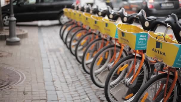 Vilnius, Lituanie. rangée de vélos colorés AVIVA à louer au stationnement municipal de vélo dans la rue . — Video