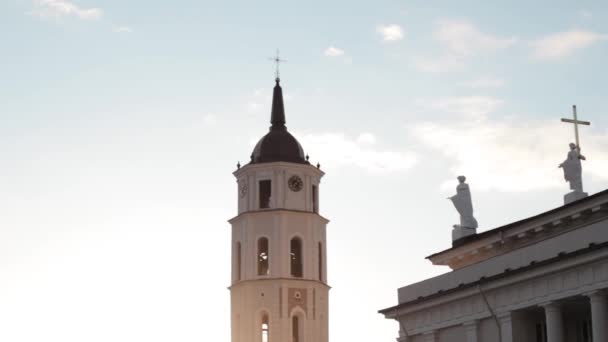 リトアニアのヴィリニュス。聖スタニスラウス大聖堂の近くの大聖堂広場を歩く人々と春の夕日の鐘楼と聖ヴラディスラフ. — ストック動画