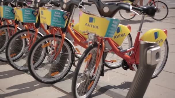 Vilnius, Lituanie. rangée de vélos colorés AVIVA à louer au stationnement municipal de vélo dans la rue . — Video