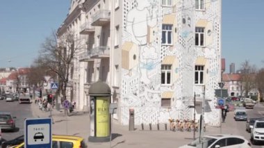 Vilnius, Litvanya. İnsanlar Bahar Gününde Boyalı Duvar Yazısı ile Ev Yakınlarında Yürüyorlar.
