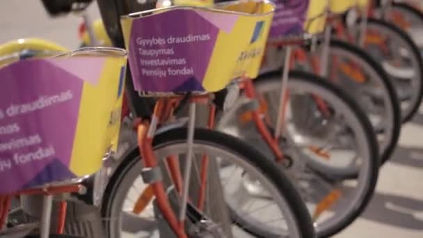 Vilnius, Lituanie. rangée de vélos colorés AVIVA à louer au stationnement municipal de vélo dans la rue . — Video