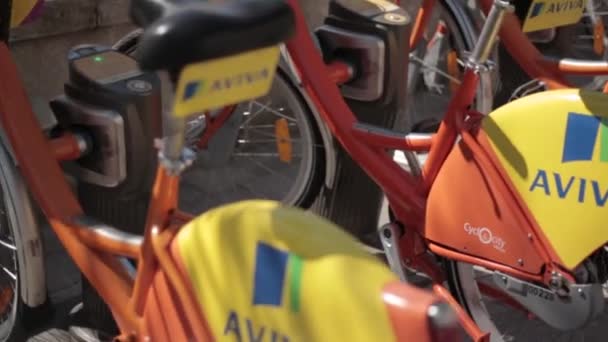 Vilnius, Lituanie. rangée de vélos colorés AVIVA à louer au stationnement municipal de vélo dans la rue . — Video