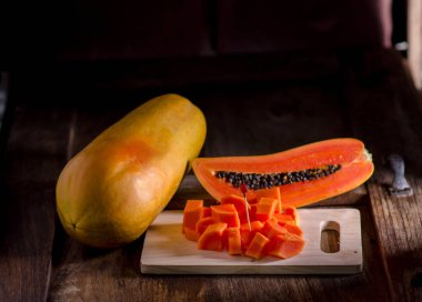 Yarım kesilmiş ve bütün papaya meyve ahşap tablo