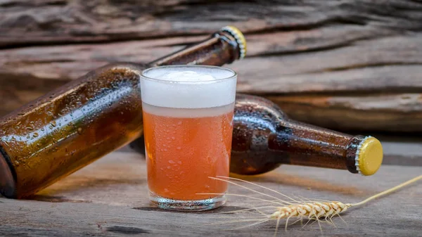 Öl i glas och flaska på träbord — Stockfoto