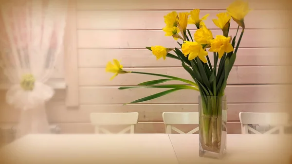Bodegón: narcisos amarillos en un jarrón sobre la mesa . —  Fotos de Stock