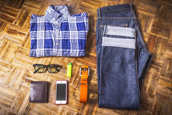 Top view of Men\'s casual outfits with man clothing and accessories on wooden background.