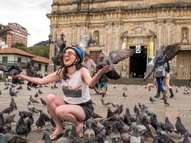 Bogota. Bir turist üzerinde oturan güvercinler de Bogota Bolivar meydanında yapıldı.