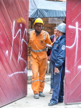 işçiler. Yenilenmiş binanın kapısında duran inşaat işçileri