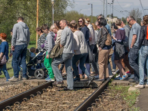 Gente. Una multitud de personas cruzando las vías del tren — Foto de Stock