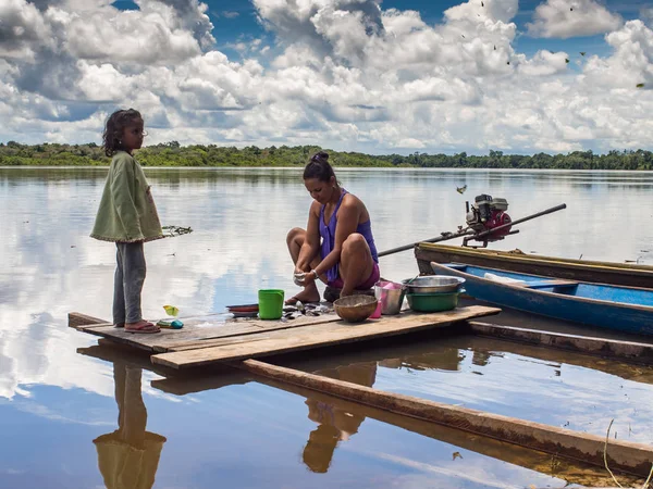 Women is washing dishes.  Women is washing dishes in the Javari river — Stock Photo, Image