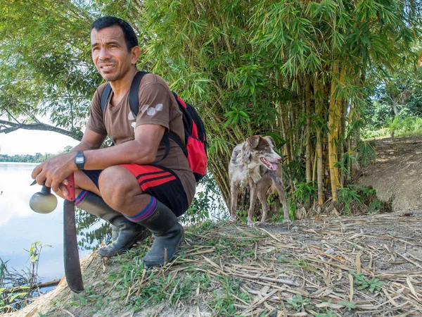 Guía local. : Un guía local con un machete está sentado bajo un árbol de bambú . — Foto de Stock