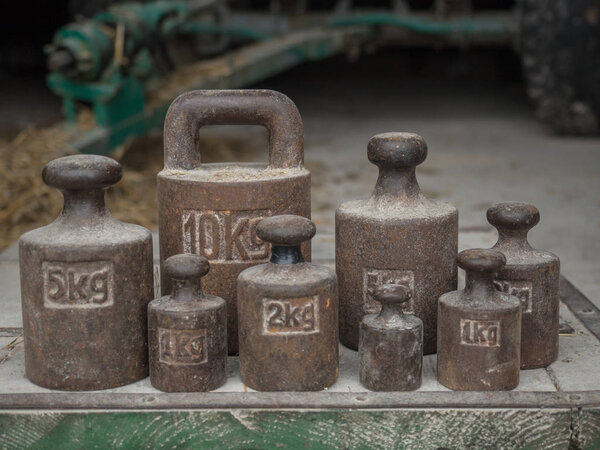 Old, metal weights of different size for a scale