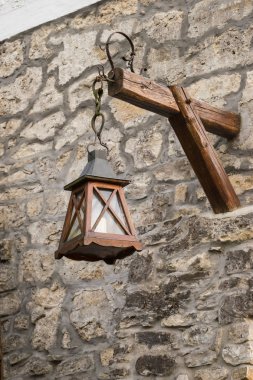 Eski fener taş duvarda asılı