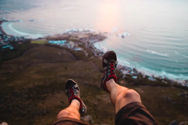 Hiker hanging legs over cliff